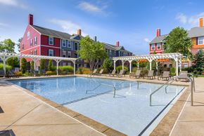 Zionsville apartment for rent - A large swimming pool in front of a red building.