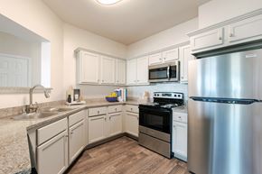 Louisville apartment for rent - A kitchen with a stainless steel refrigerator and white cabinets.