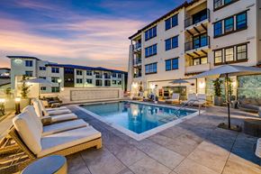 Santa Rosa apartment for rent - A large outdoor pool surrounded by lounge chairs and umbrellas.