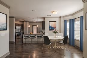 Prosper apartment for rent - A modern dining room with a white table and chairs.