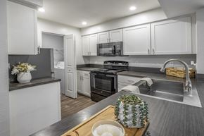 Tampa apartment for rent - A modern kitchen with a wooden cutting board on the counter.