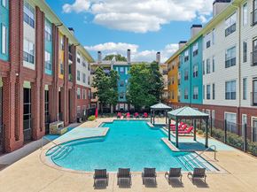 Atlanta apartment for rent - A pool with chairs and a gazebo in front of apartment buildings.