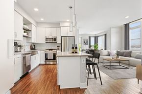 Denver apartment for rent - A modern kitchen with white cabinets and a wooden island.