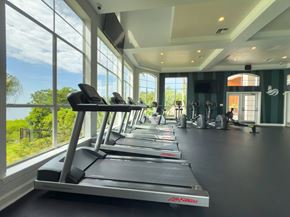 Clearwater apartment for rent - A gym with treadmills and a view of the outdoors through large windows.