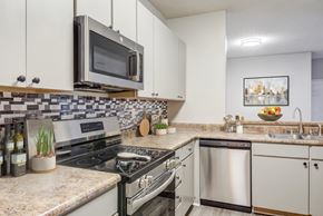 Murfreesboro apartment for rent - A kitchen with a stove top oven, microwave, and a sink.