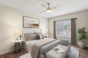 Murfreesboro apartment for rent - A bedroom with a large bed, a ceiling fan, and a potted plant.