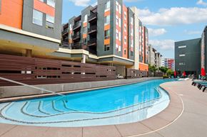 Denver apartment for rent - A swimming pool in front of apartment buildings.