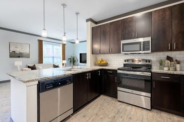 Louisville apartment for rent - A modern kitchen with dark brown cabinets and stainless steel appliances.