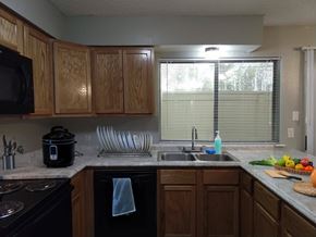 Nacogdoches apartment for rent - A kitchen with wooden cabinets and a black stove top oven.