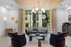 San Antonio apartment for rent - A living room with a brown chair and a table with a vase of flowers on it.