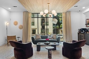San Antonio apartment for rent - A living room with a brown chair and a table with a vase of flowers on it.