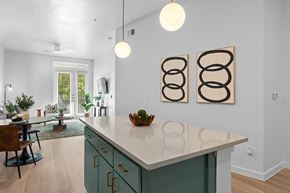 San Antonio apartment for rent - A kitchen with a white counter top and green cabinets.