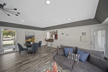 Mesquite apartment for rent - A modern living room with a grey couch and a dining table.
