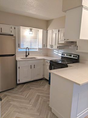 Austin apartment for rent - A kitchen with a refrigerator, stove, and cabinets.