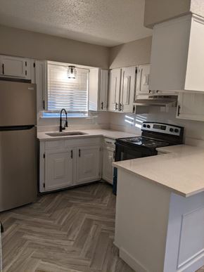 Austin apartment for rent - A kitchen with a refrigerator, stove, and cabinets.