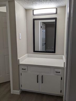 Austin apartment for rent - A white vanity with a mirror and a light above it.
