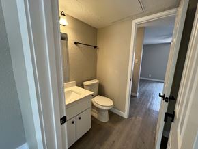 Austin apartment for rent - A bathroom with a toilet, sink, and mirror.