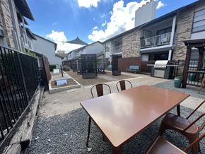 Austin apartment for rent - A patio with a table and chairs is surrounded by buildings.