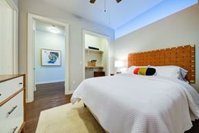 San Antonio apartment for rent - A bedroom with a bed, a dresser, and a painting on the wall.
