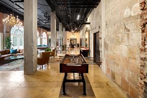 San Diego apartment for rent - A room with a shiny wooden table and a brick wall.