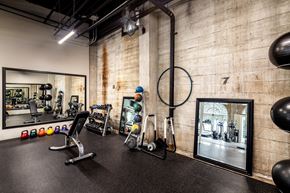 San Diego apartment for rent - A gym with a variety of equipment including a weight bench, a mirror, and a punching bag.