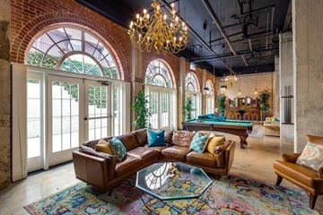 San Diego apartment for rent - A living room with a brown leather couch and a chandelier.