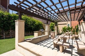 Escondido apartment for rent - A patio with a wooden pergola and concrete furniture.