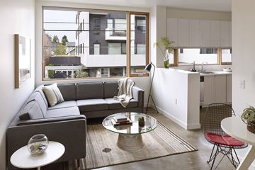 Portland apartment for rent - A modern living room with a grey couch and a glass coffee table.