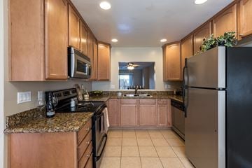 La Mesa apartment for rent - A kitchen with wooden cabinets and black appliances.