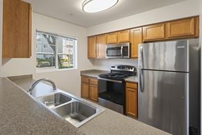 Renton apartment for rent - Kitchen with stainless steel appliances and oak cabinetry at Valley Springs Apartments, Renton, Washington