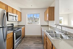 Renton apartment for rent - A kitchen with a stainless steel refrigerator, oven, and sink.