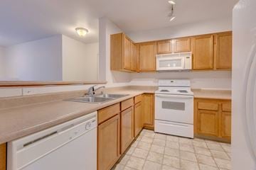 Renton apartment for rent - A kitchen with white appliances and wooden cabinets.
