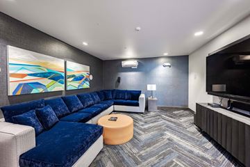Kirkland apartment for rent - A living room with a blue couch and a television.