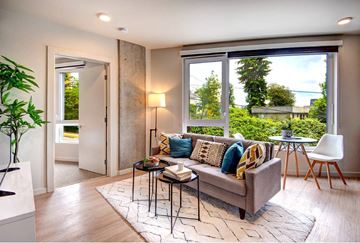 Seattle apartment for rent - A living room with a grey couch and a black metal table.