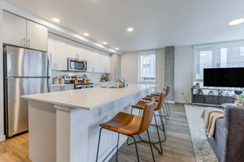 A modern kitchen with a white countertop and stainless steel appliances.
