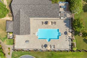 Millington apartment for rent - A large swimming pool surrounded by a stone patio and a grassy lawn.