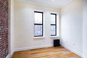 Brooklyn apartment for rent - A room with a brick wall and two windows.