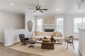 Cordova apartment for rent - A living room with a white couch, a black chair, a brown coffee table, and a fireplace.