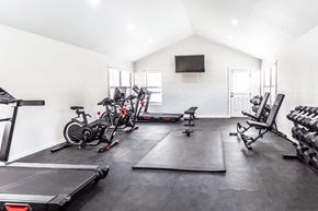 Memphis apartment for rent - A home gym with a treadmill, exercise bikes, and weights.