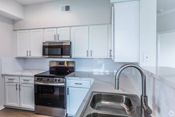 Cordova apartment for rent - A kitchen with white cabinets and a stainless steel sink.
