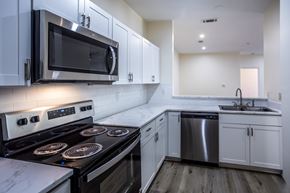 Millington apartment for rent - A modern kitchen with a stove top oven and microwave above it.