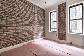 Brooklyn apartment for rent - A room with a brick wall and two windows.