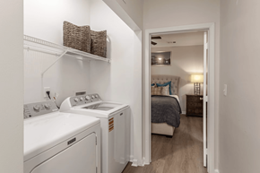 Millington apartment for rent - A laundry room with a washer and dryer and a bedroom with a bed and nightstand.