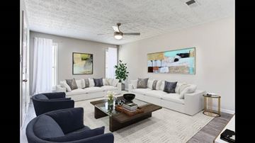 Clarkson apartment for rent - A living room with a white couch, a blue armchair, and a painting on the wall.