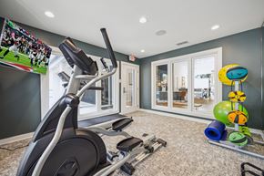 San Antonio apartment for rent - A home gym with a television screen showing a football game.