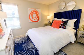 Hendersonville apartment for rent - A bedroom with a white bed and a blue carpet.
