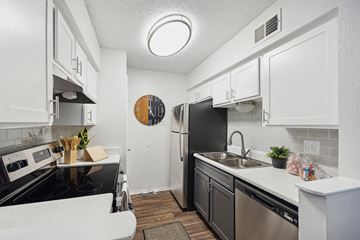 San Antonio apartment for rent - A kitchen with black appliances and white cabinets.