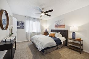 San Antonio apartment for rent - A bedroom with a bed, nightstand, and a ceiling fan.