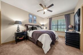 New Braunfels apartment for rent - A bedroom with a bed, nightstands, and a ceiling fan.
