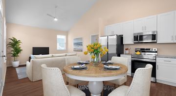 Leland apartment for rent - A modern kitchen and living room with a dining table set for two.